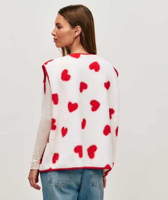 Sleeveless sherpa jacket with red heart pattern;