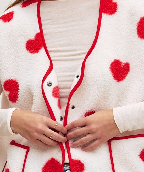 Sleeveless sherpa jacket with red heart pattern;