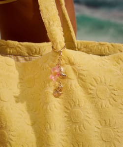 Golden keychain with seashells and hibiscus;