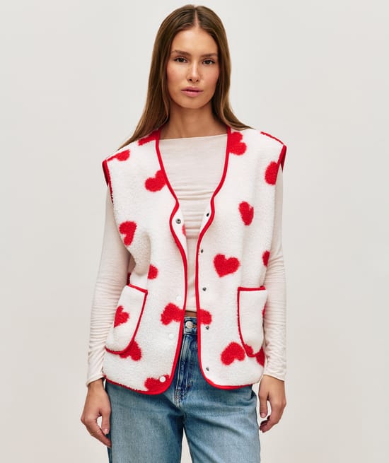 Sleeveless sherpa jacket with red heart pattern;