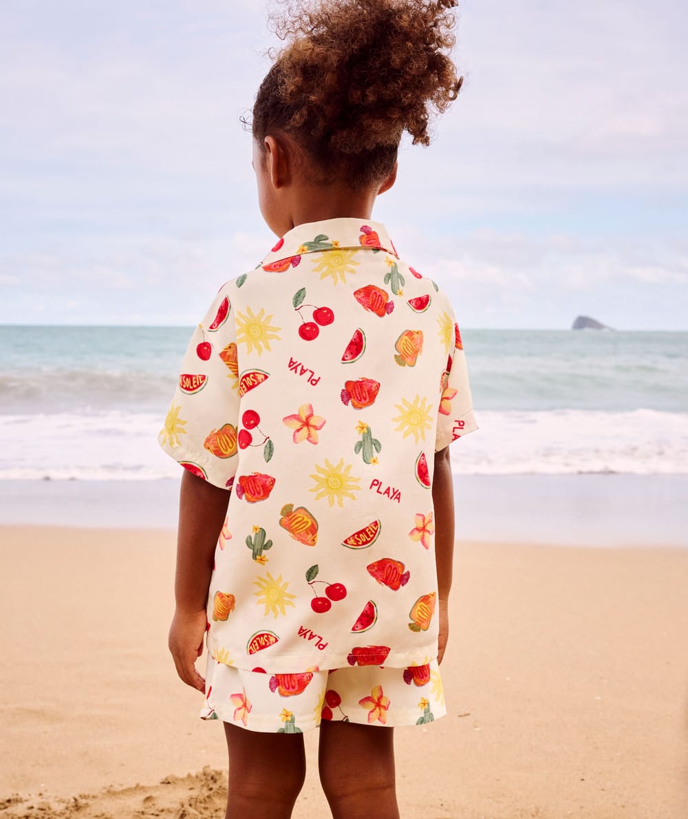 Short-sleeved shirt and patterned fruit and flower shorts;