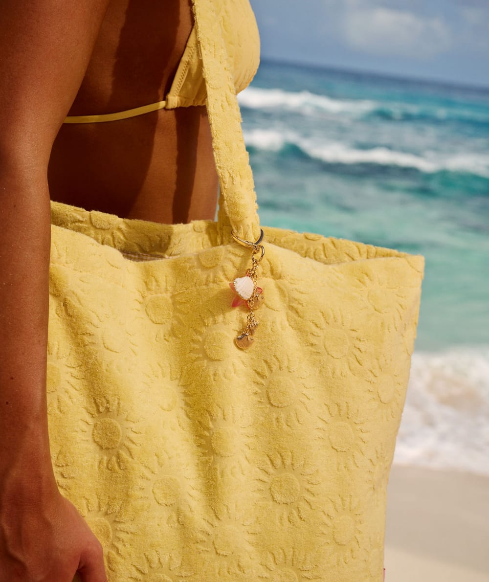 Golden keychain with seashells and hibiscus;