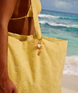 Golden keychain with seashells and hibiscus;