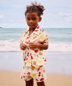 Short-sleeved shirt and patterned fruit and flower shorts;