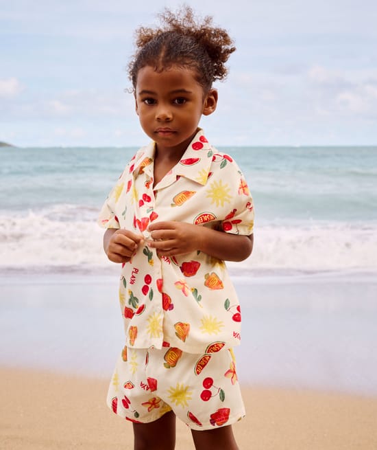 Short-sleeved shirt and patterned fruit and flower shorts;